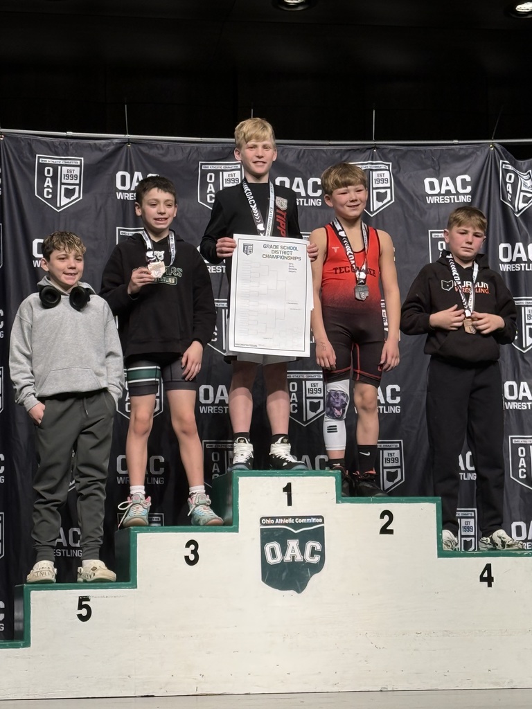 A student on the podium for his first place win. 