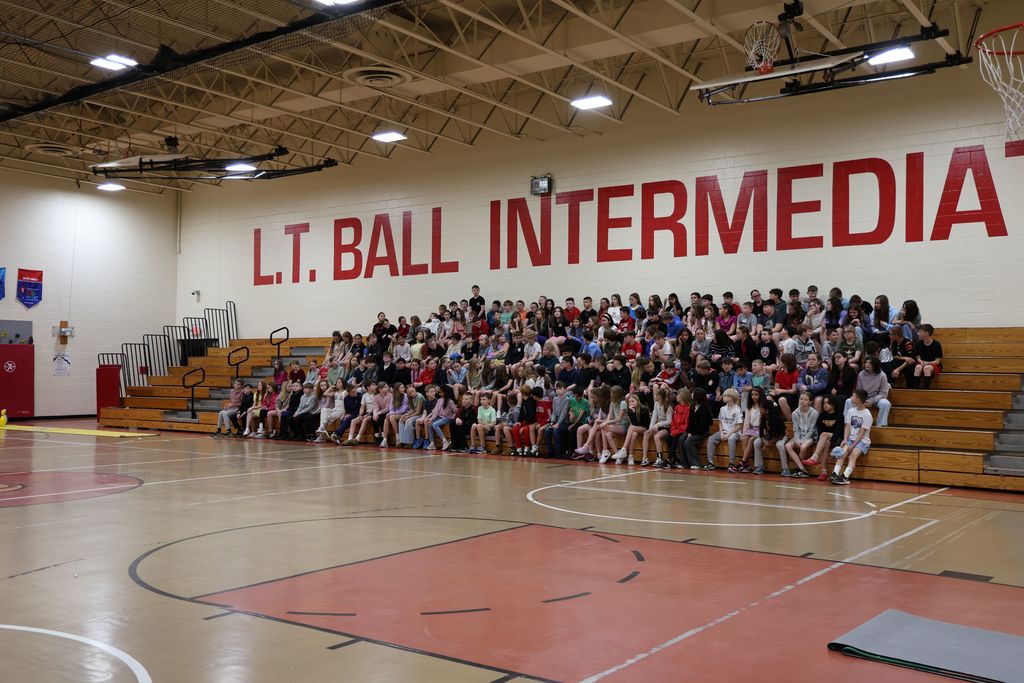 The entire fifth grade class is seated in the bleachers for the class picture.