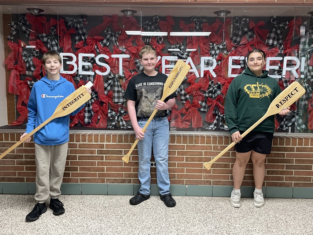 TMS students stand with oars to represent PBIS  and being selected as the Crew of the Week.