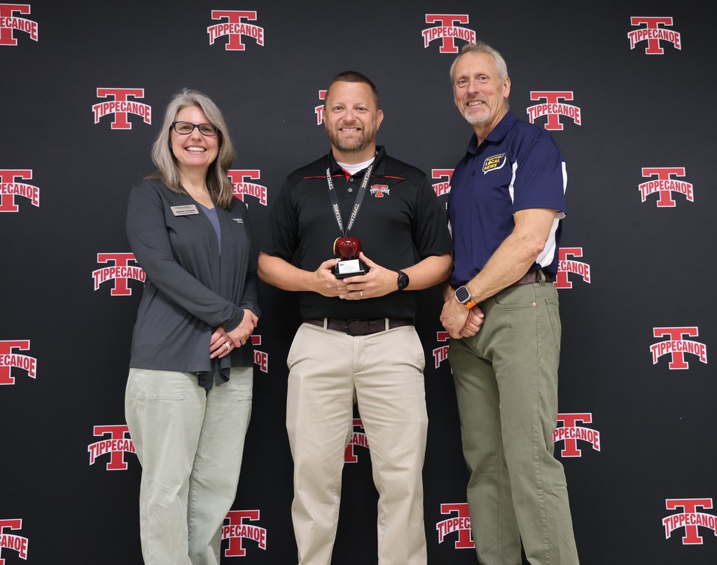 L.T. Ball teacher Matt Lieber, the recipient of the Golden Apple award stands with two who presented the award.