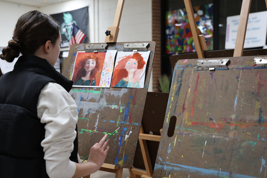 A student looks at her art project and it is a wow.