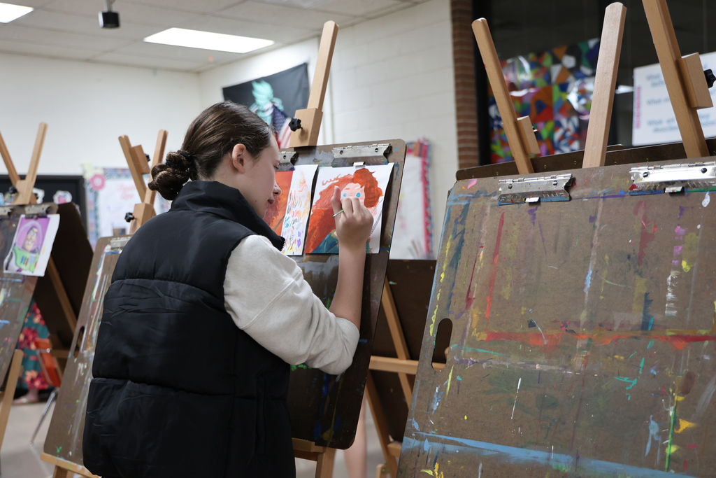 TMS student works on her art project at an easel.