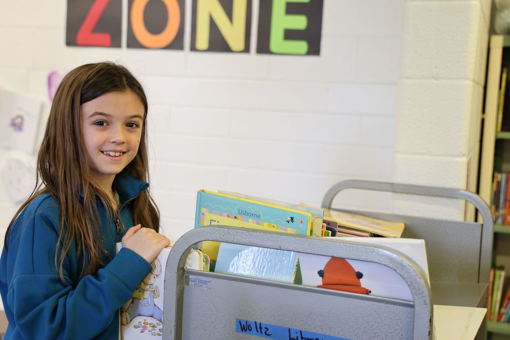 A Broadway student selecting a book.
