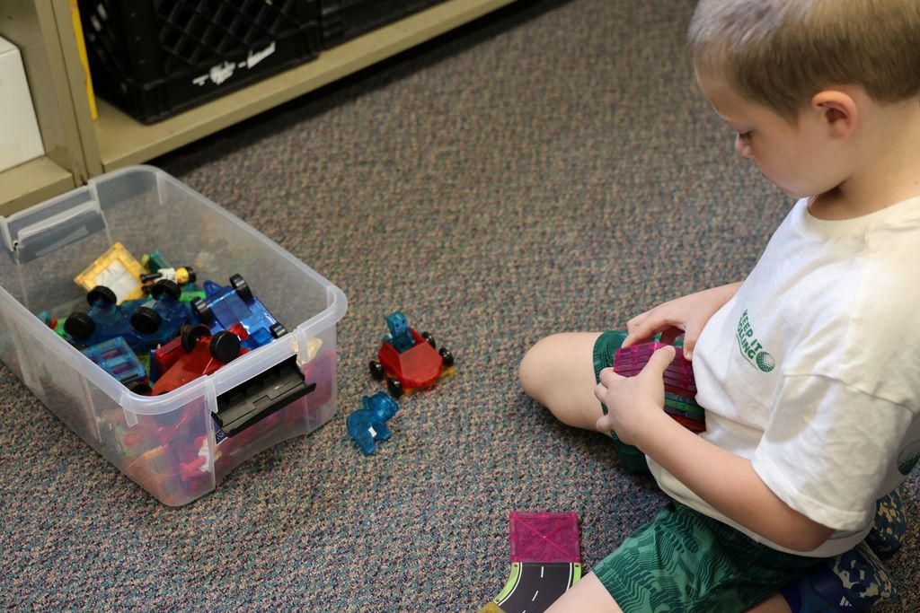 A student takes time to work with magnetic tiles.  