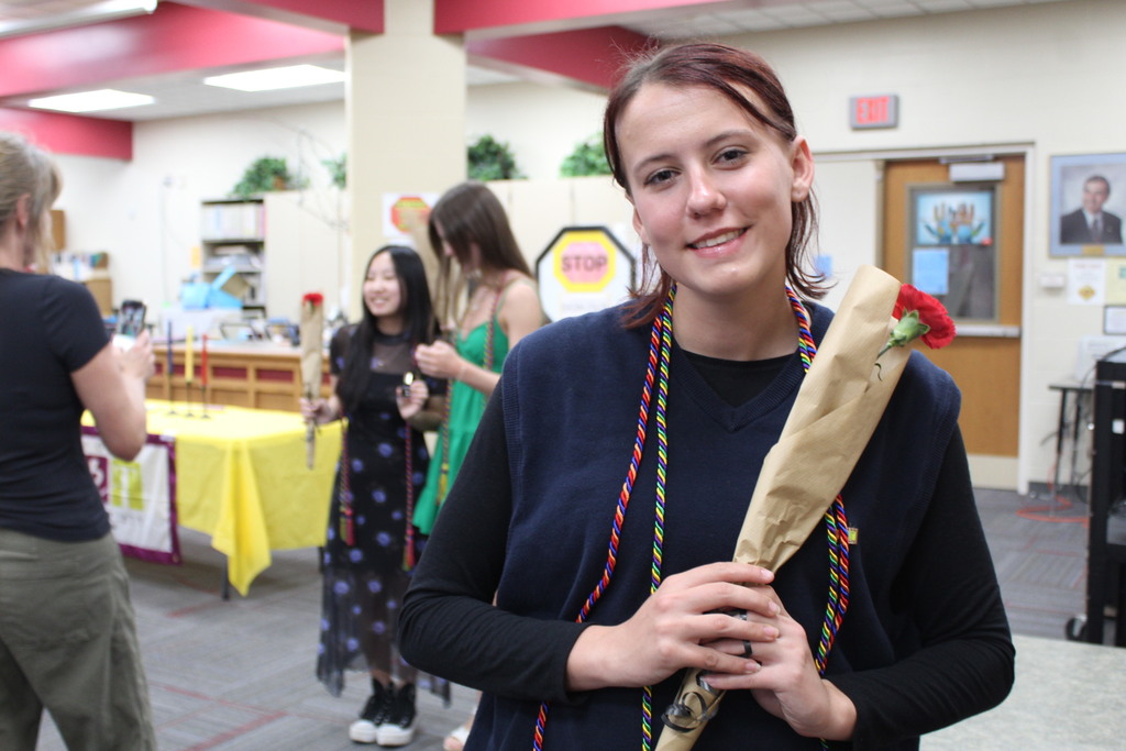 A NAHS inductee holds her flower and wears her cords.