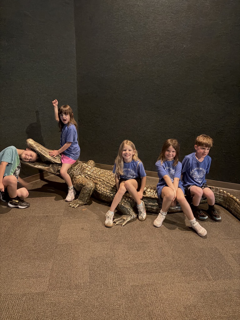 Broadway Elementary students at the Cincinnati Zoo sit on an alligator statue.