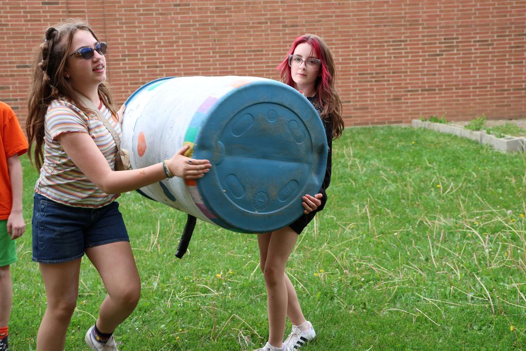 TMS students carry the rain barrel. 