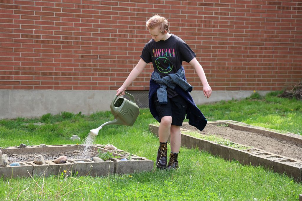 A TMS student waters the garden. 