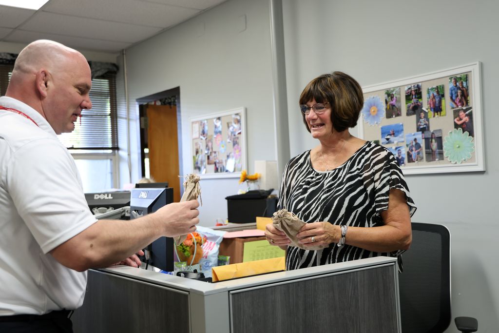 Mr. Moran giving a gift to Mrs. Derringer.