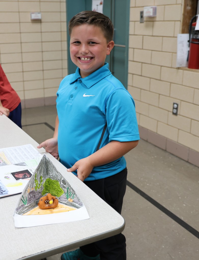 A Broadway student stands with her animal project.  