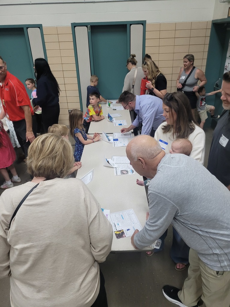 Guests look at projects prepared by first graders.  