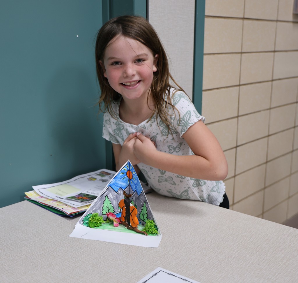 A Broadway student stands with her animal project.  