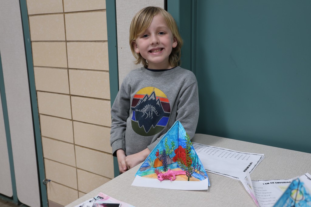 A Broadway student stands with her animal project.  