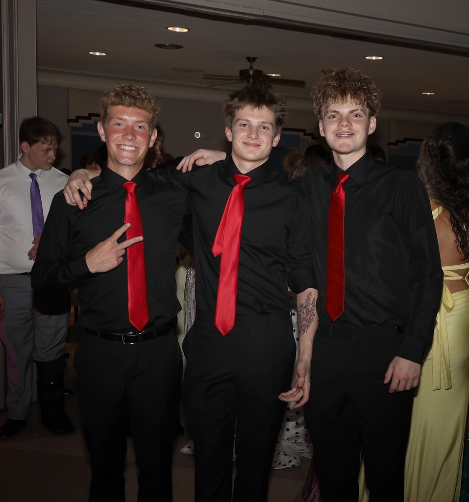 Three THS boys in matching shirts and ties pose for a photo at prom.