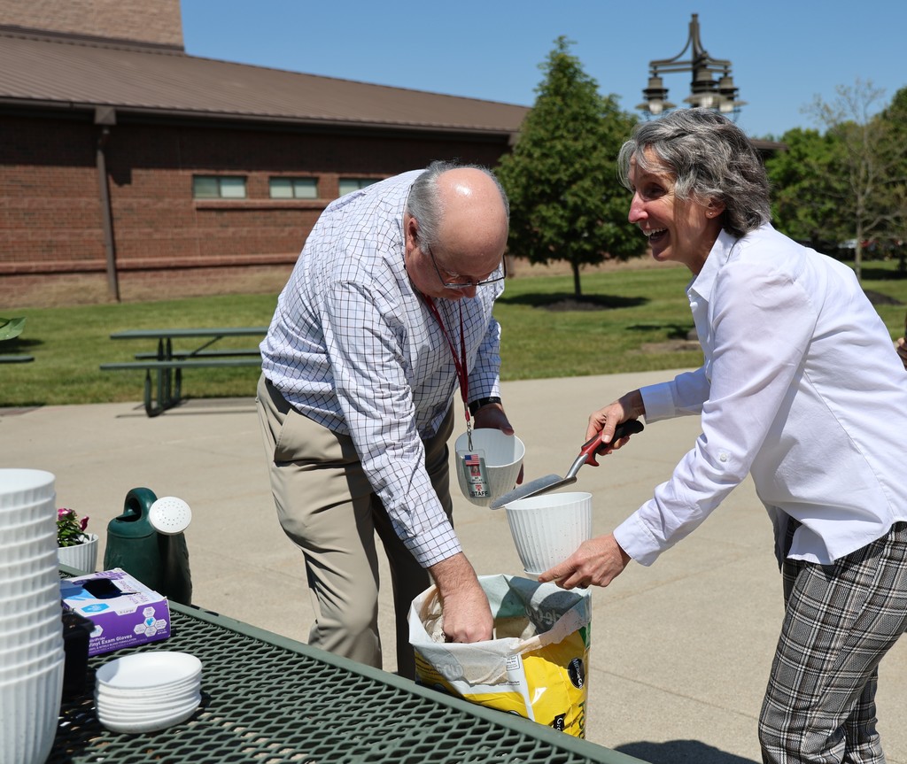 THS staff members plant flowers in a take home flower pot.
