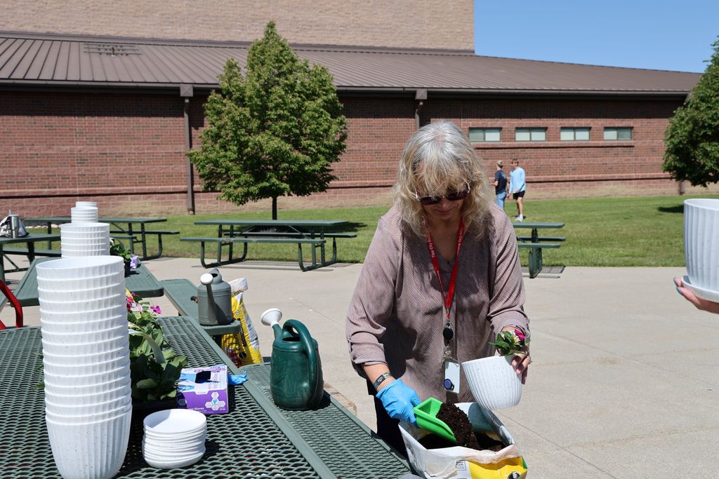 THS staff members planted a flower in a take home flower pot.