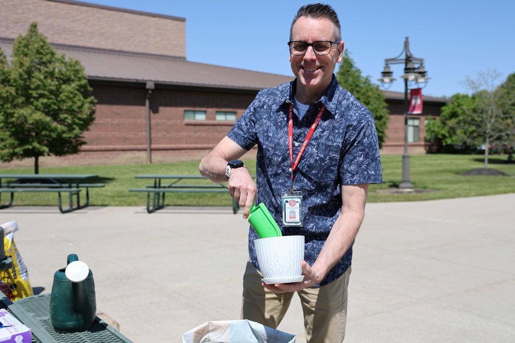 THS staff members planted a flower in a take home flower pot.