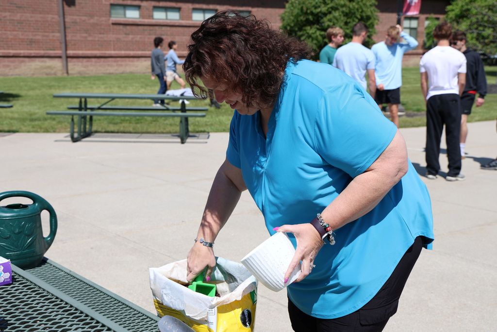 THS staff member fills the take home flower pot with dirt.