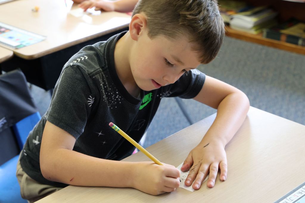 A student writes out his note of appreciation for a teacher.  