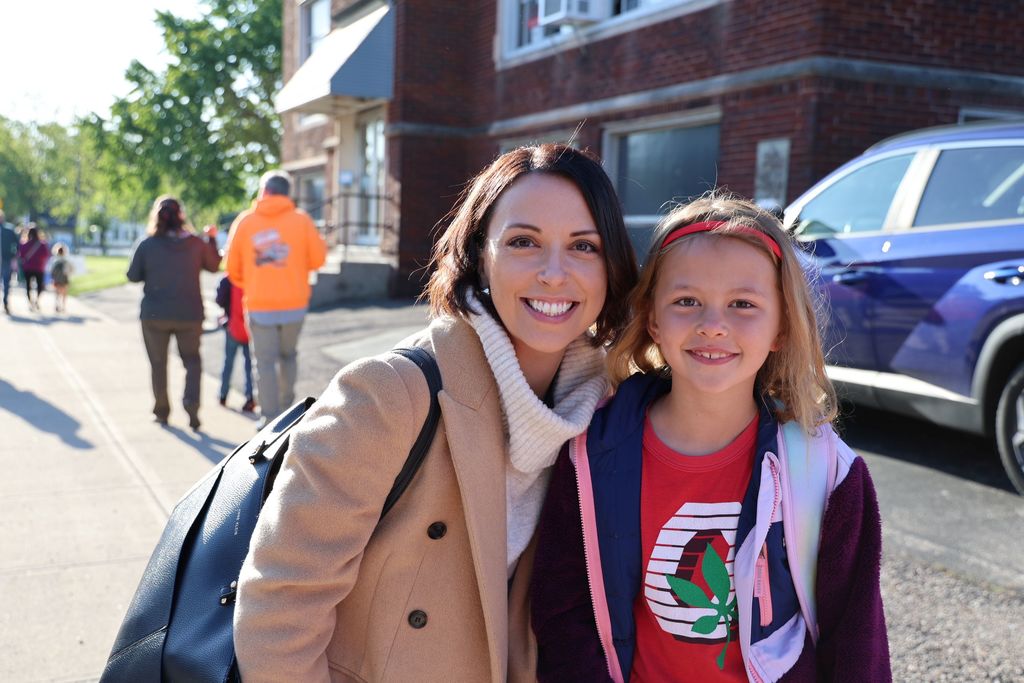 A mom and her daughter smile at Muffins in the Morning.  