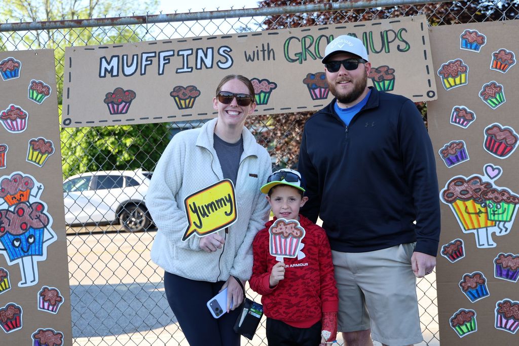 A student with his parents in the photo booth at Muffins in the Morning.  