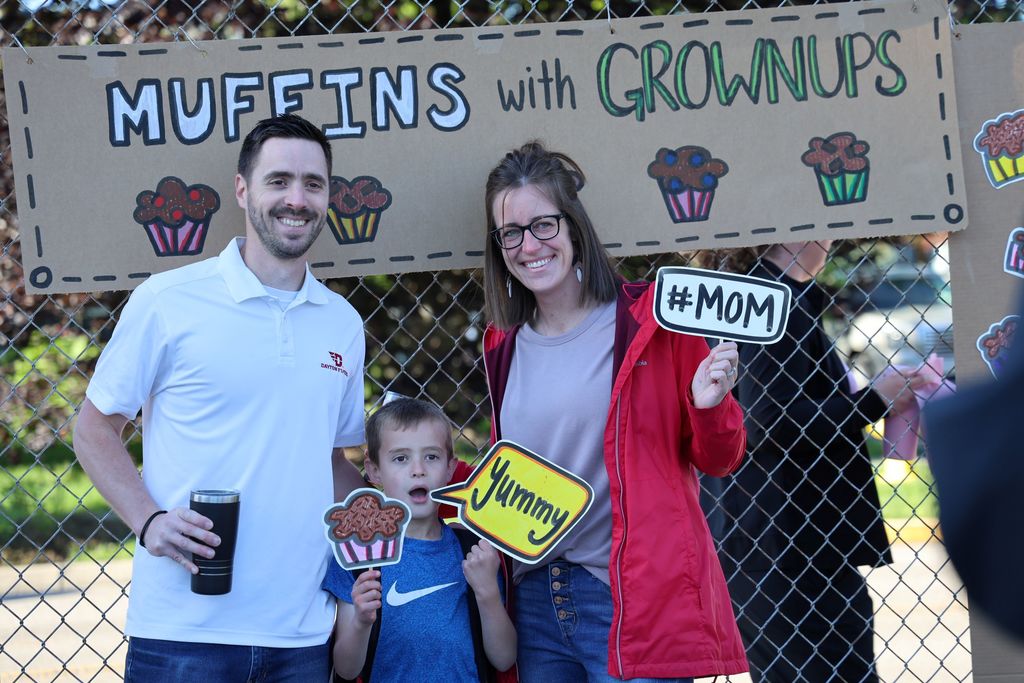 A student and his parents pose in the photo booth.  