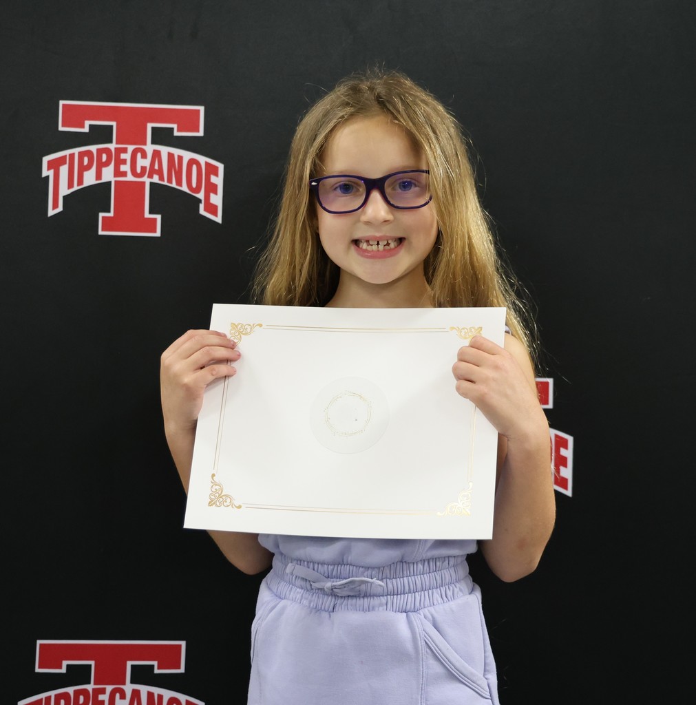 Broadway Elementary student holds her certificate and smiles after being honored by the BOE.
