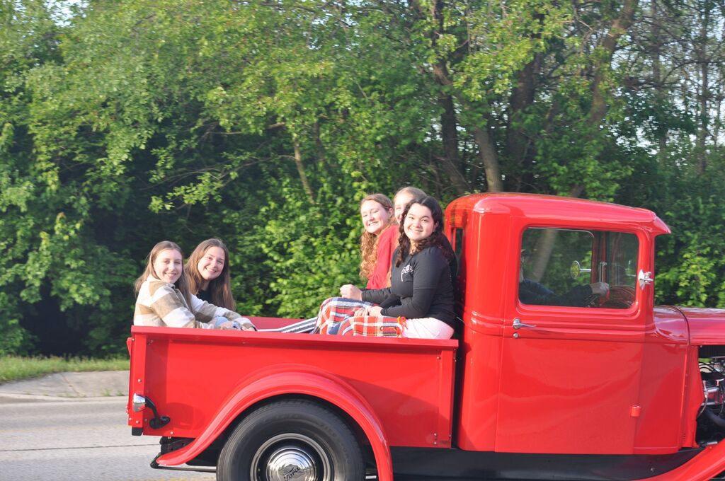 THS students in the back of an old red truck on their way to school.