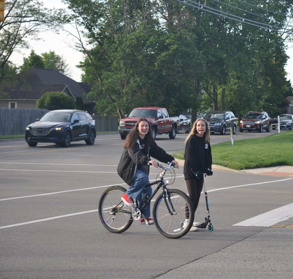 THS students on a bike and a scooter on their way to the last day of classes.