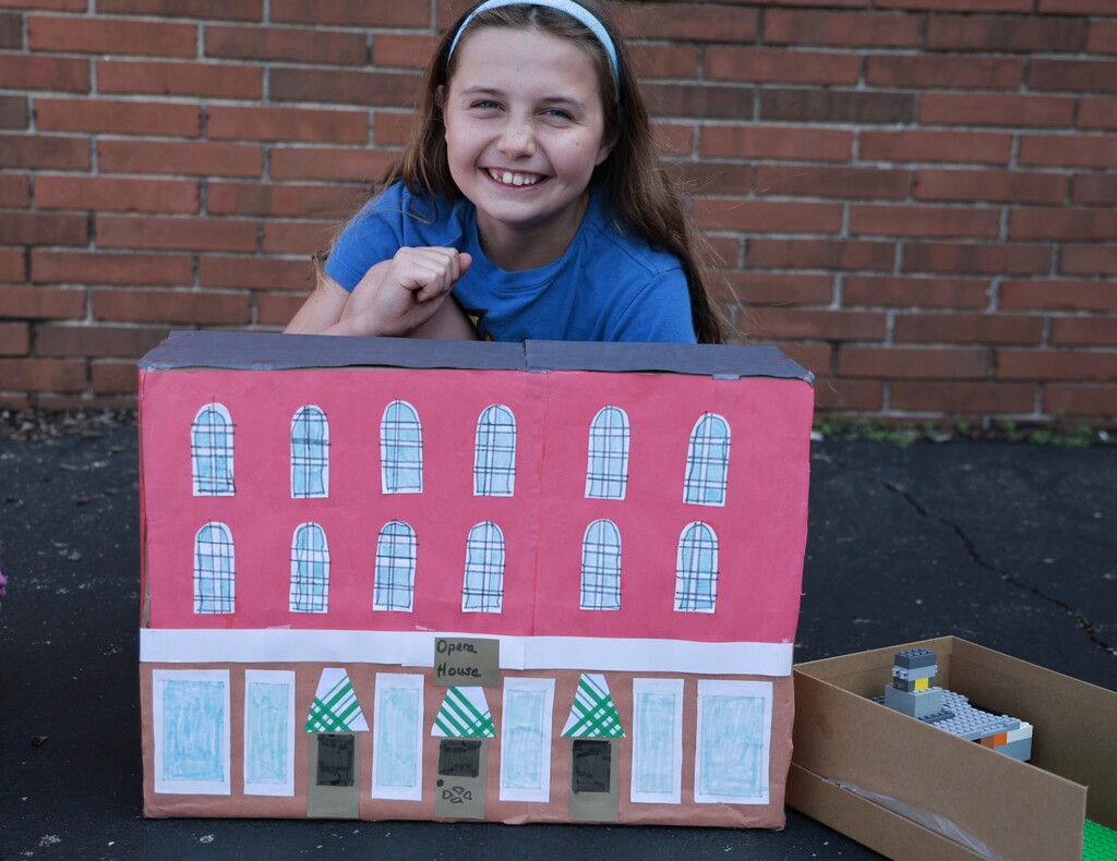 An LT Ball student shows off the Tipp City float of the Opera House created for class.  