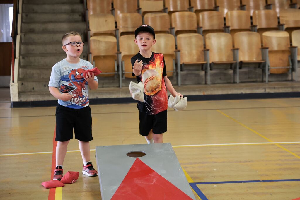 Two boys play cornhole at field day.  