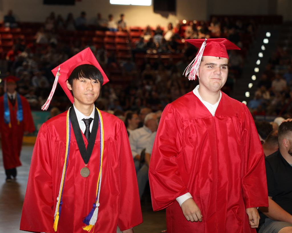 Two students enter the ceremony.