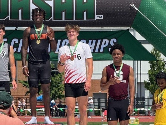 THS track runner stands on the podium with his medal at the OHSAA track and field state meet.