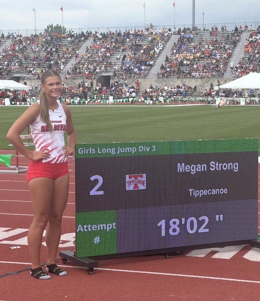 THS student Megan Strong stands next to the sign with her name and long jump stat.