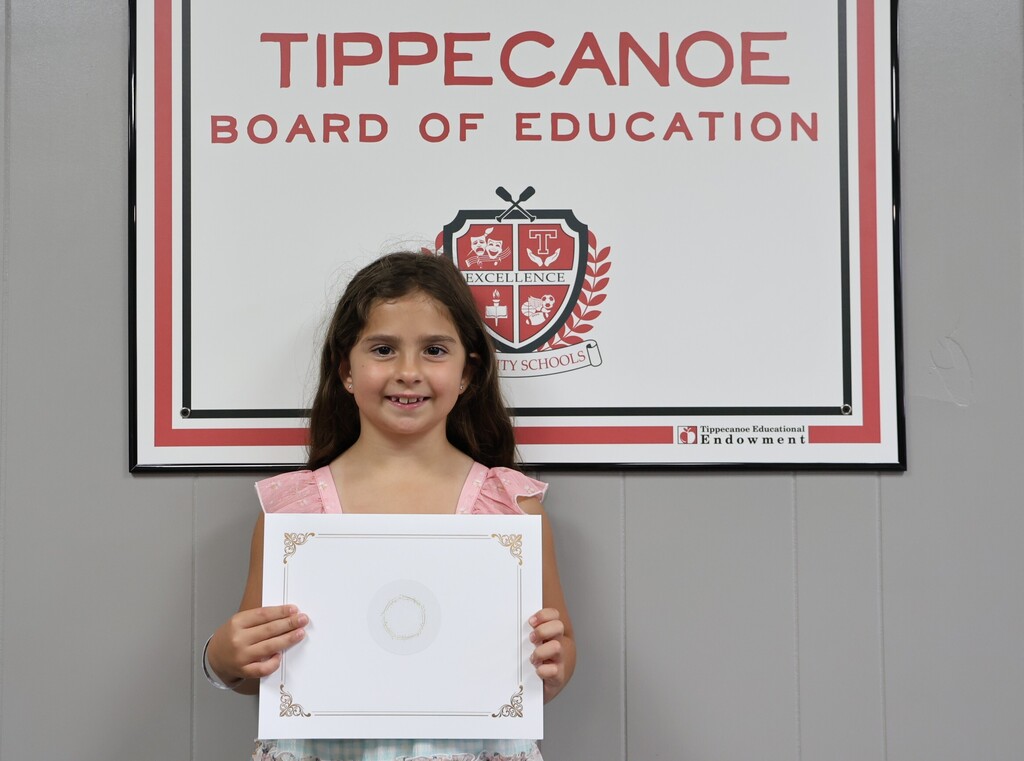 Broadway Elementary student poses with her certificate.