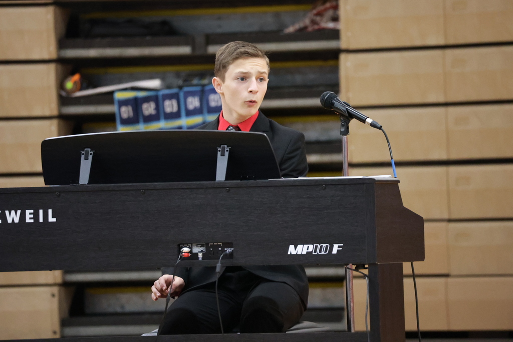 A students plays the keyboard and sings.