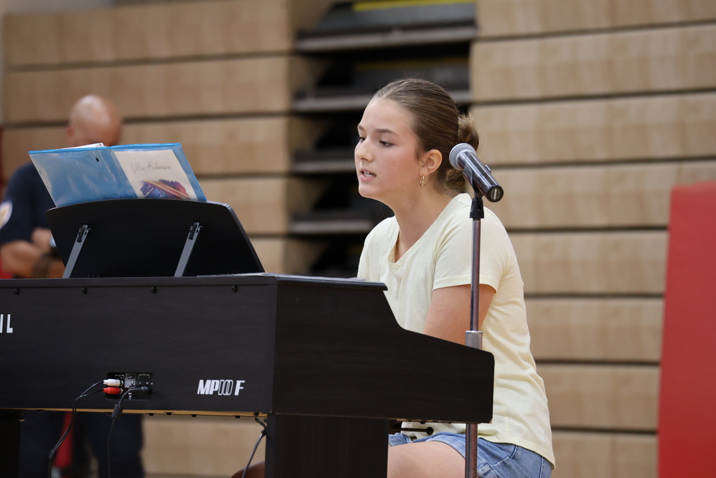 A student plays the keyboard and sings at the talent show.