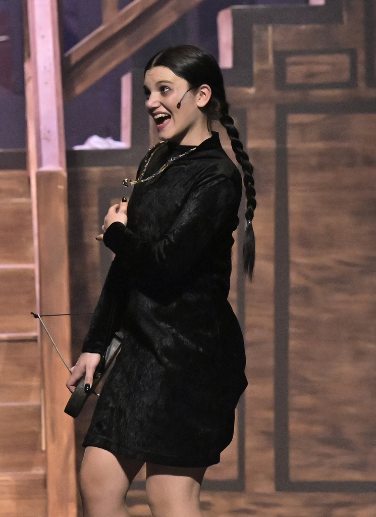 A student performs in the spring musical as Wednesday Addams.