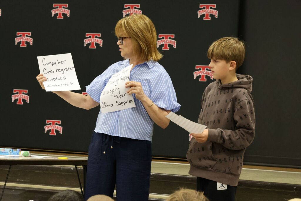 The owner of Topsy Turvy interacts with a student to demonstrate what it takes to run a local business. 