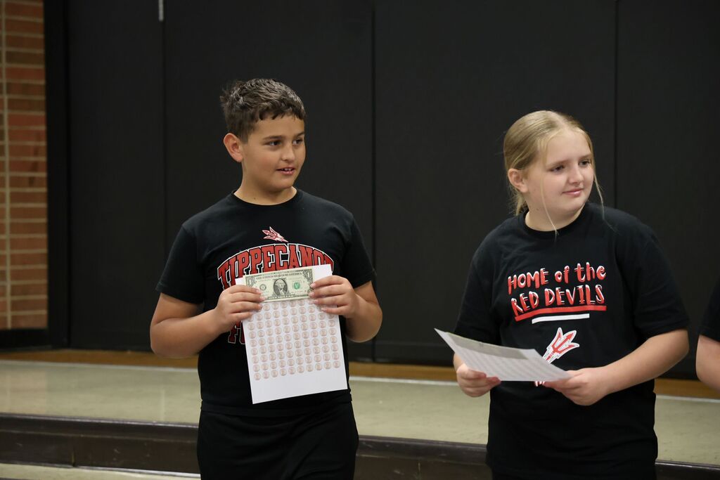 Two L.T. Ball students help the guest speaker present economic concepts of running a  business.
