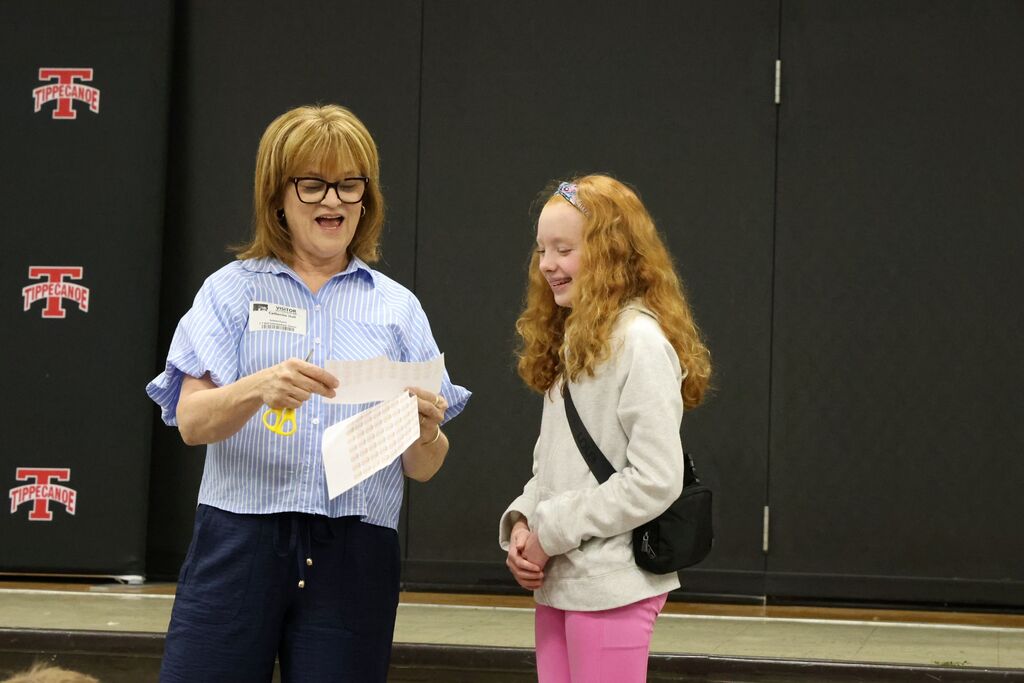 The owner of Topsy Turvy interacts with a student to demonstrate what it takes to run a local business. 