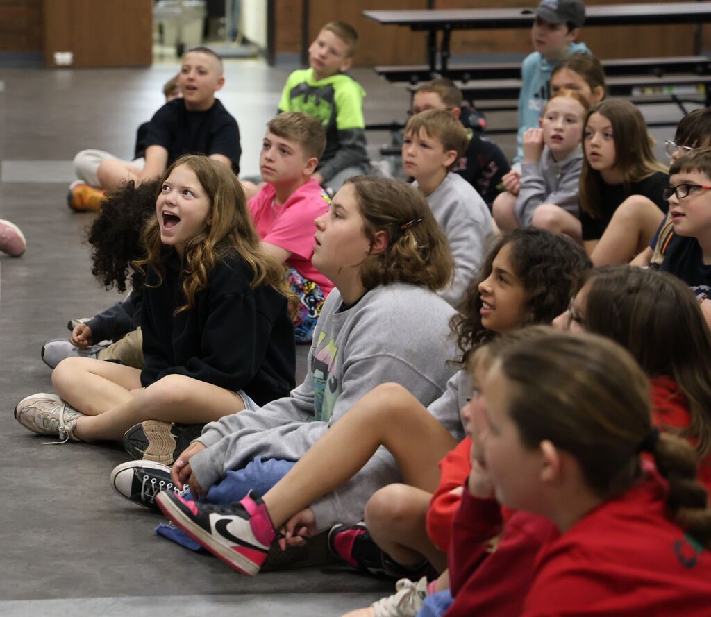Students react with laughter and smiles as they listen to and learn from a guest speaker.