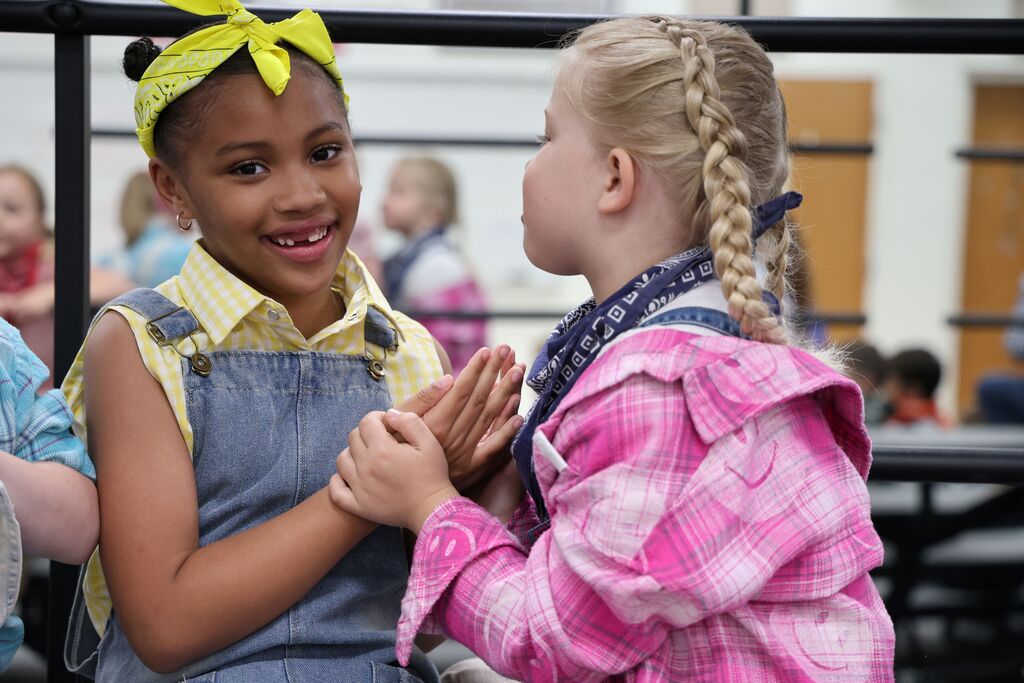 Two kindergarten students embrace each other.  