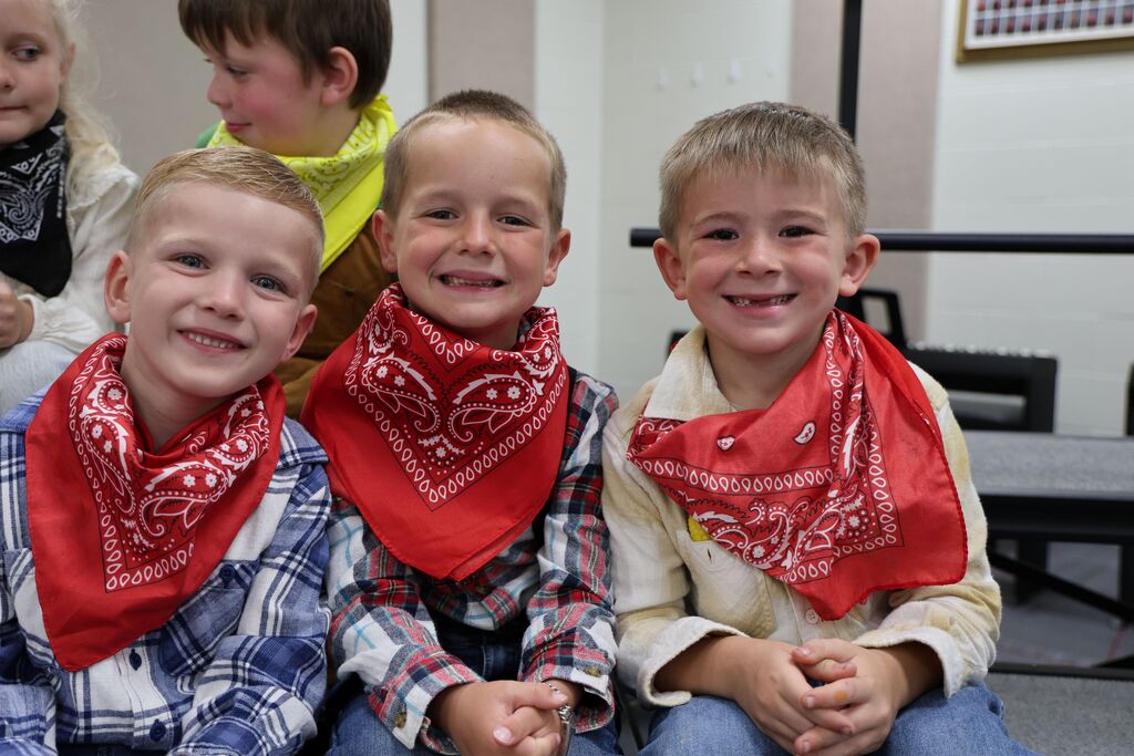 Three boys in their red bandanas smile before their Moosical.