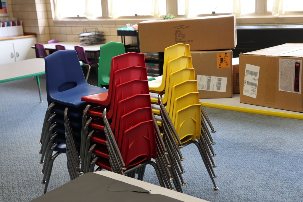Chairs are stacked and boxes need to be unpacked.