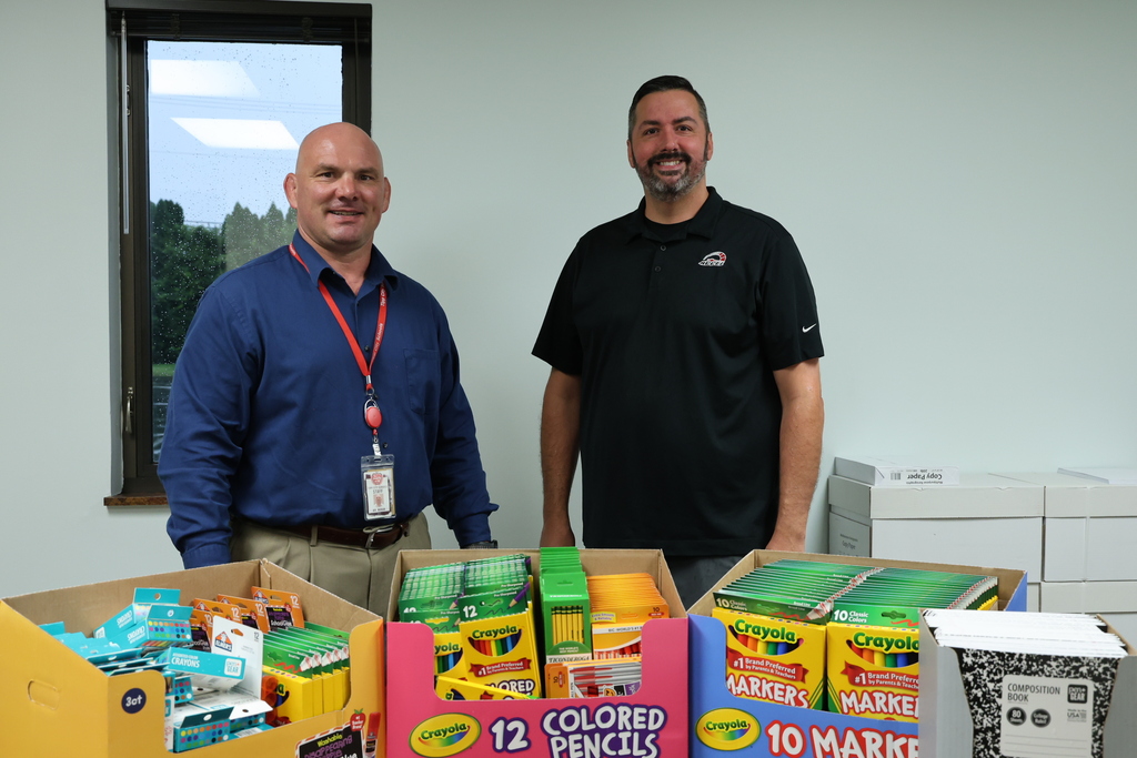 Superintendent with owner of Accel automotive and the school supplies the business donated.