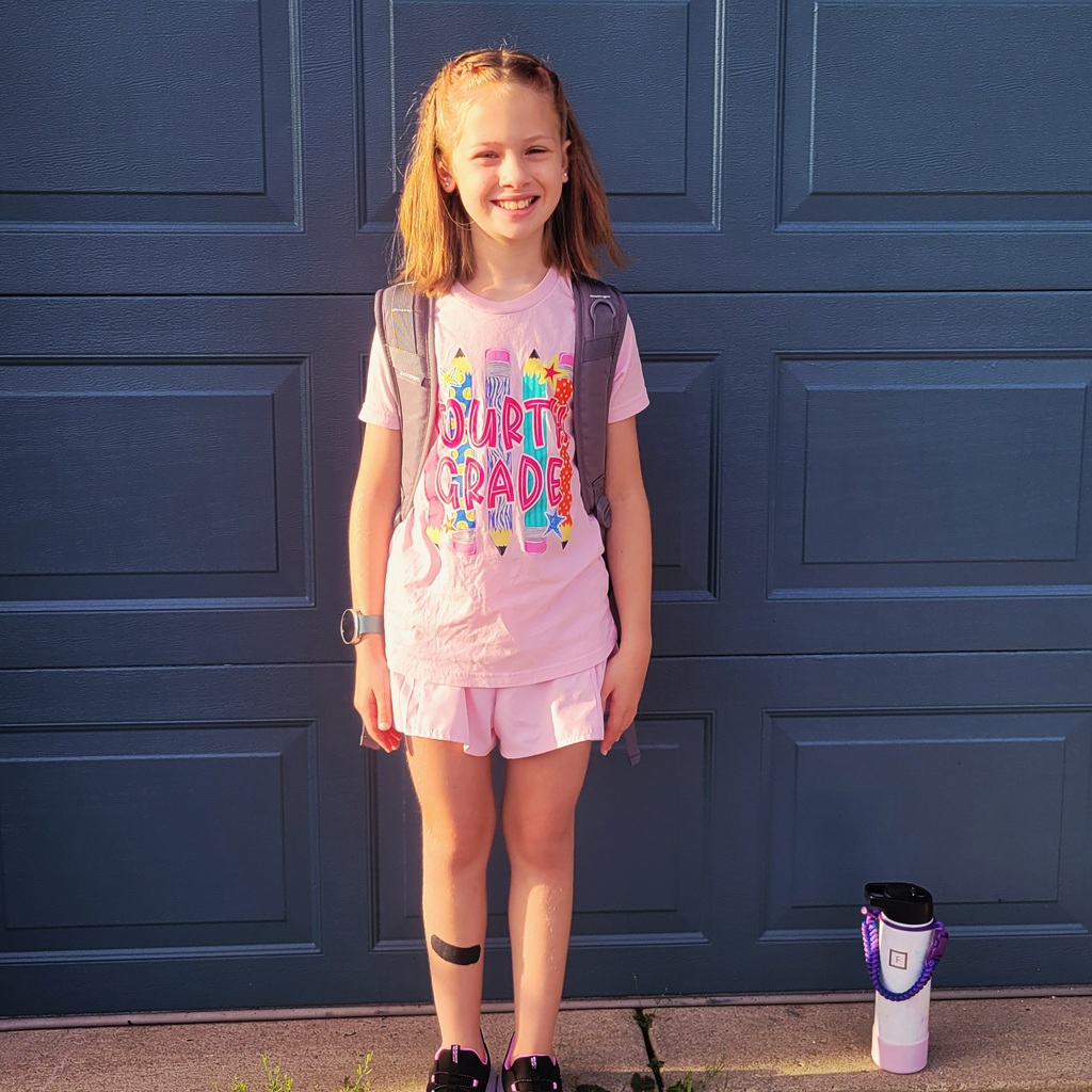An fourth grader poses for her first day of school photo.