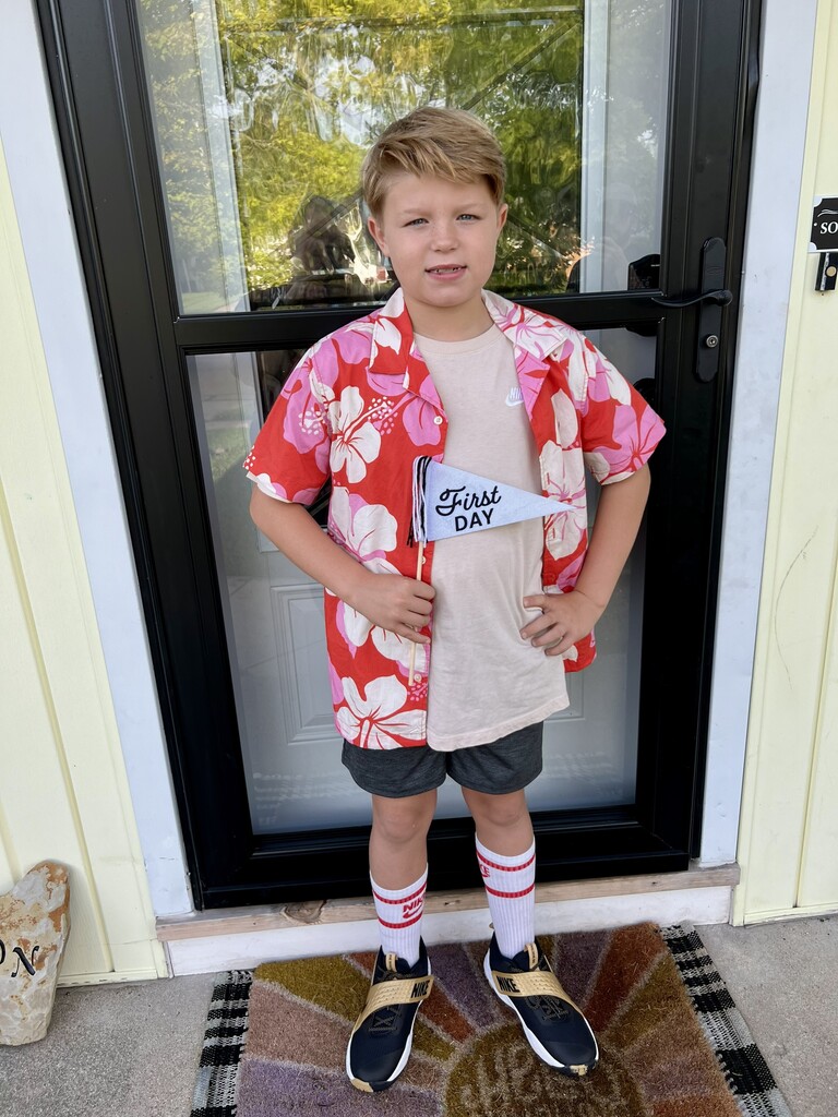 A little boy poses for his first day of school photo.