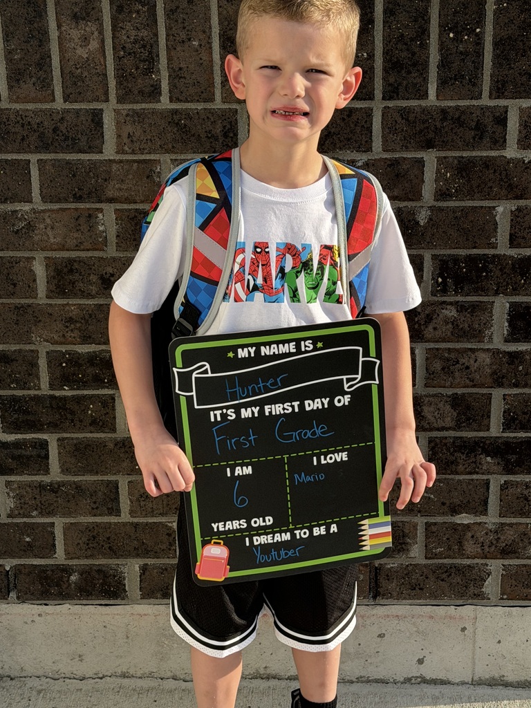 A student poses for his first day of school photo.