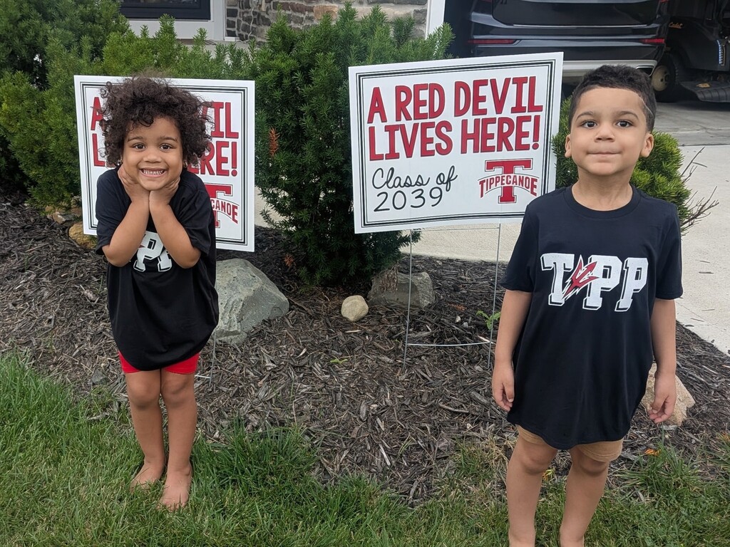 Set of twins with their kindergarten signs.